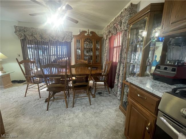 Carpeted dining area with ceiling fan | Image 17