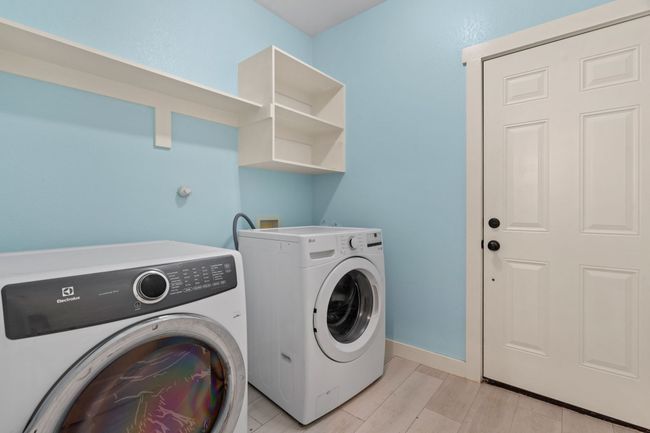 Washroom featuring washing machine and dryer and light wood-type flooring | Image 17