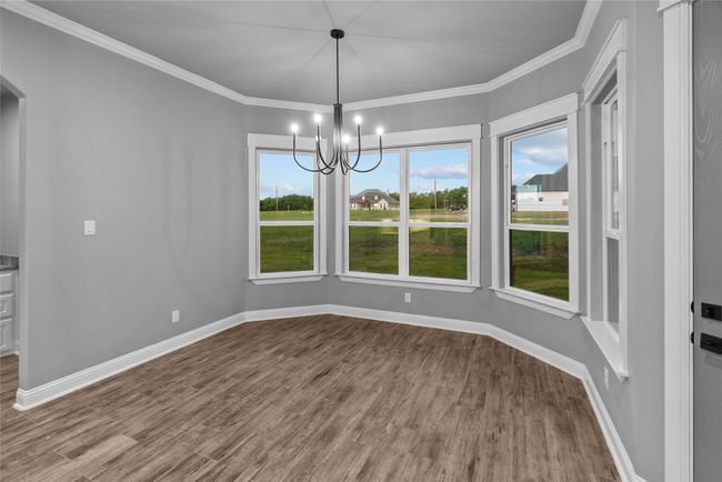 Unfurnished dining area featuring wood finished floors, a chandelier, arched walkways, and crown molding | Image 11