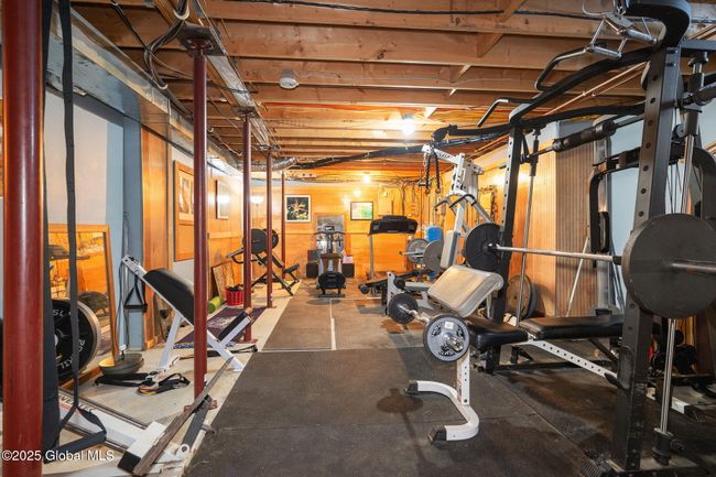 Basement unfinished area with 9-ft ceiling, currently used as a home gym | Image 36