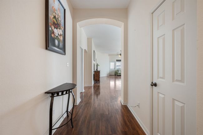 Corridor featuring arched walkways, baseboards, and dark wood-style flooring | Image 11