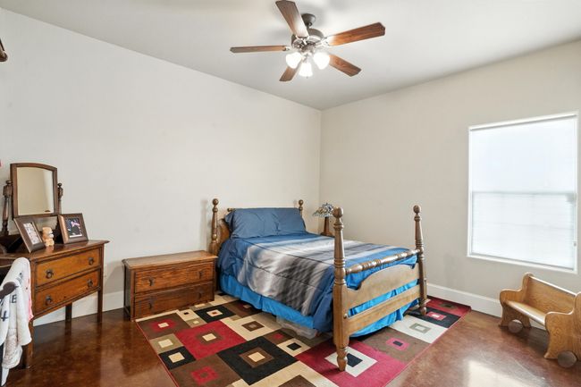 Bedroom with finished concrete floors and ceiling fan | Image 23