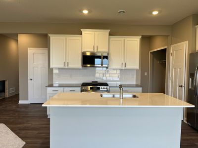 (*Photo of another Glacier plan home, actual homes finishes will vary) Enjoy this spacious kitchen with stylish finishes and a large kitchen island to accommodate seating. | Image 2