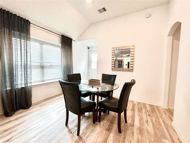 Kitchen/dining room combo with abundant natural light. Door leads to the backyard and arched opening leads to primary retreat. | Image 11