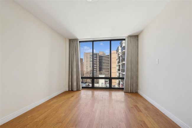 Empty room featuring a view of city, light wood-style floors, expansive windows, and baseboards | Image 6