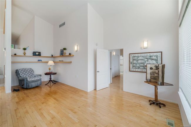 Living area with high vaulted ceiling, wood finished floors, and baseboards | Image 26