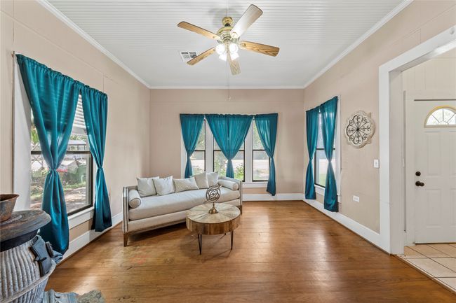 Living room with crown molding, a ceiling fan, and hardwood / wood-style flooring | Image 8