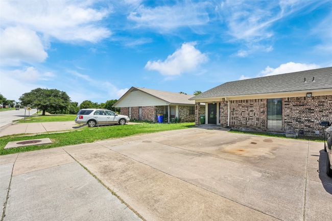 Ranch-style home with brick siding, a front yard, a shingled roof, and driveway | Image 22