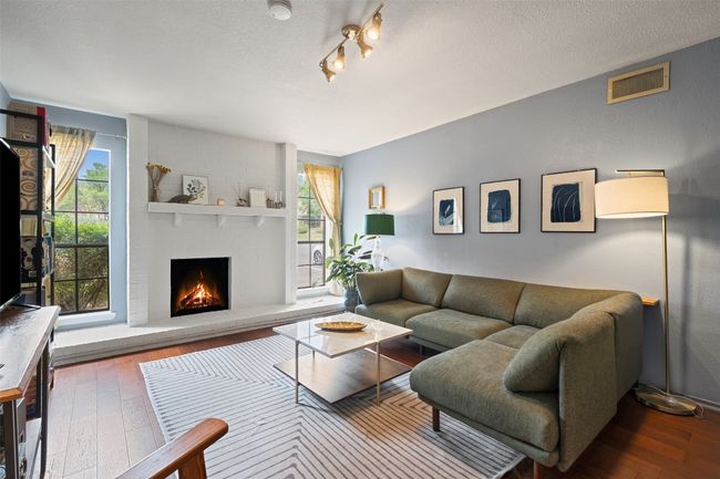 Living area featuring a textured ceiling, a fireplace, and hardwood / wood-style floors | Image 11