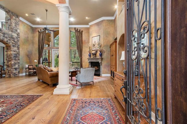 The walls of windows and doors allow a direct line of sight upon entrance through the entire house to the lush flower gardens, serene backyard and mature trees. | Image 4