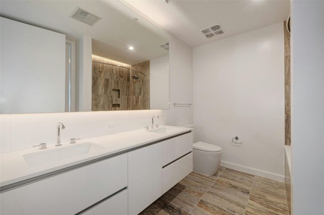 Bathroom featuring a tile shower, a sink, visible vents, and toilet | Image 24