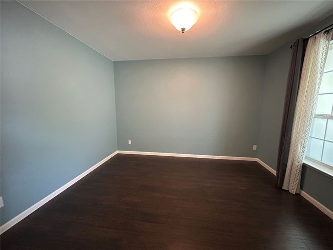 Unfurnished room featuring dark wood-style flooring and baseboards | Image 7