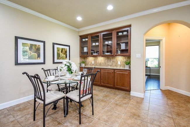 Set beside the kitchen, this breakfast corner is well-lit and enhanced by custom upper glass cabinets with built-in lighting, creating a café-like atmosphere. | Image 17