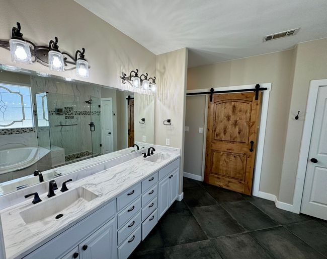 Full bath with visible vents, a garden tub, a sink, and a marble finish shower | Image 15