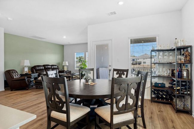 Dining space featuring light wood finished floors, visible vents, and recessed lighting | Image 15