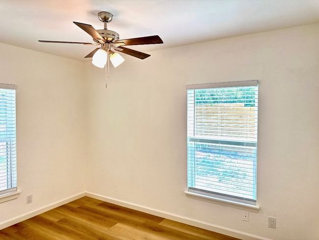 Spare room featuring wood finished floors, baseboards, and a ceiling fan | Image 16