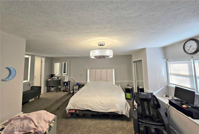 Carpeted bedroom with a textured ceiling | Image 33