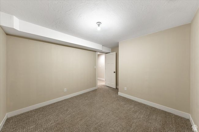 Finished below grade area featuring baseboards, carpet floors, and a textured ceiling | Image 51