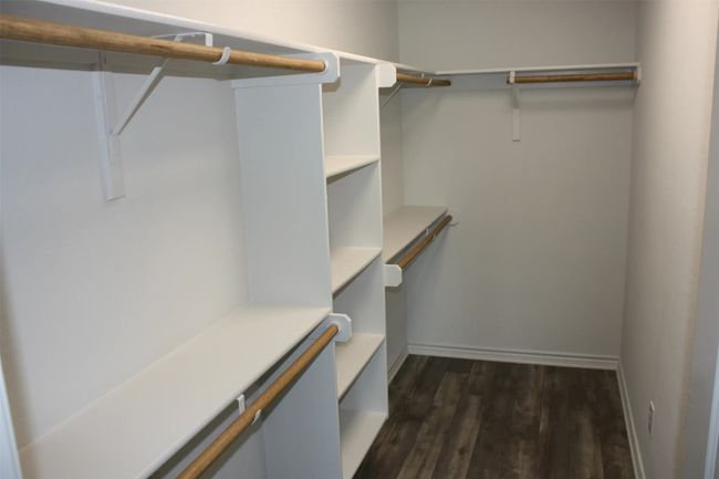 Walk in closet with dark wood-style flooring | Image 8