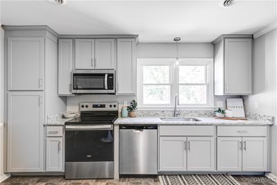 Kitchen with sink, light stone countertops, gray cabinets, and stainless steel appliances | Image 3