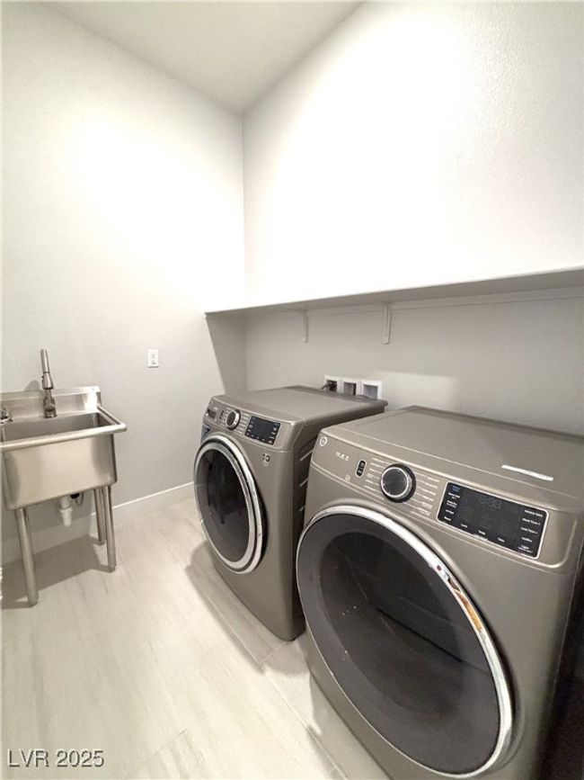 Laundry room with a sink, independent washer and dryer, laundry area, baseboards, and light floors | Image 33