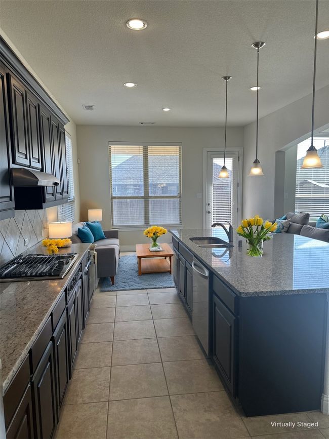 Kitchen with a sink, open floor plan, gas stovetop, and dishwasher | Image 6
