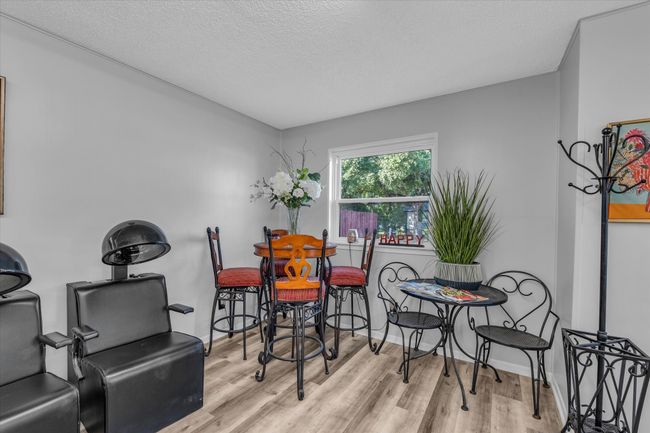 Dining room with a textured ceiling, wood finished floors, and baseboards | Image 8