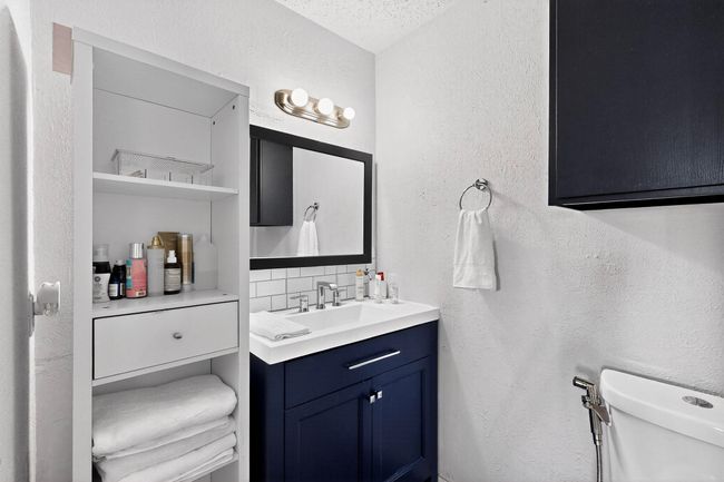 Bathroom with a textured wall, vanity, backsplash, and a textured ceiling | Image 14