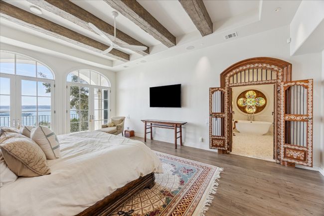 The imported antique double doors with ivory inlay lead to the lavish primary bathroom. | Image 19