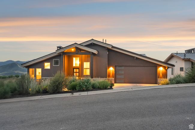 Mid-century modern home with a garage, concrete driveway, and a chimney | Image 9