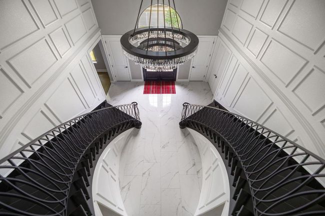 Staircase featuring marble finish floor, a towering ceiling, and baseboards | Image 25