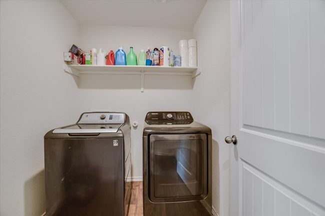 Laundry area featuring independent washer and dryer, laundry area, and wood finished floors | Image 17