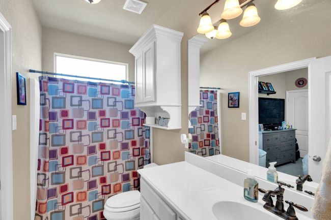 Full bathroom featuring toilet, a chandelier, vanity, and a shower with shower curtain | Image 15