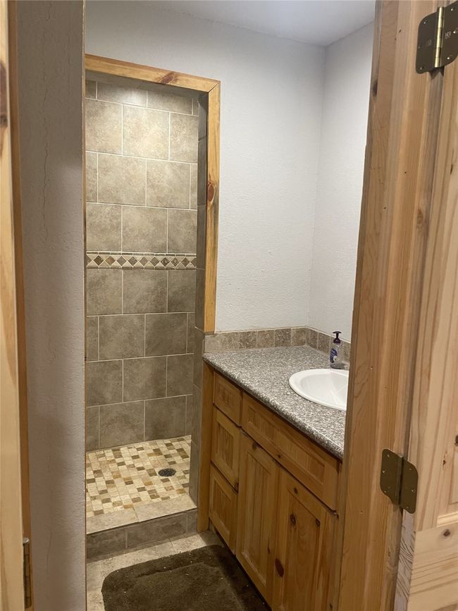 Bathroom featuring tiled shower and vanity | Image 29