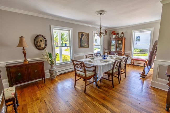 Dining room with ornamental molding, a chandelier, hardwood / wood-style flooring, a decorative wall, and a wainscoted wall | Image 45