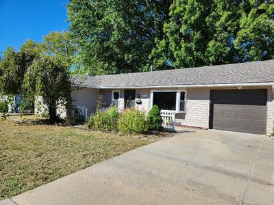 Ranch-style house with a front yard and a garage | Image 1