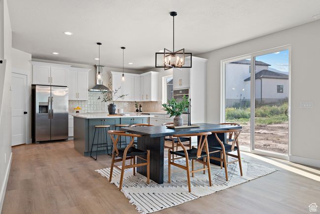 Dining room featuring light wood-style floors, a chandelier, and recessed lighting | Image 9