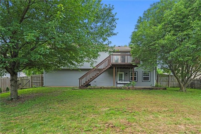 Rear view of property featuring stairs, a wooden deck, and a fenced backyard | Image 38