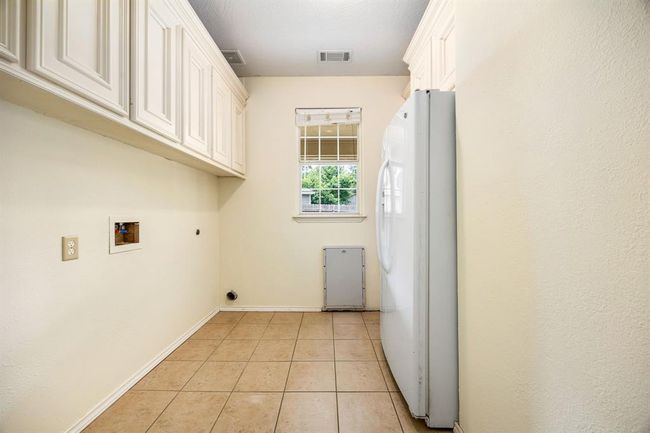 The surplus of cabinet space is continued into the laundry room. There is a large row of cabinets above the washer/dryer area and even above the refrigerator. This laundry room is large enough to fit a full size refrigerator and deep freezer. | Image 22