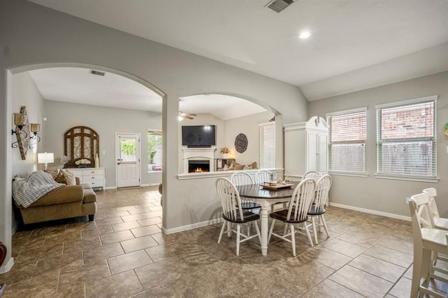The dining area offers a bright, welcoming space for meals, with views into the living room through graceful archways that provide an open feel while still defining each space. | Image 13