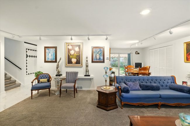 Living area featuring rail lighting, stairs, and baseboards | Image 5
