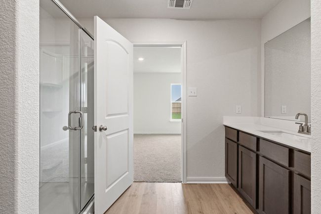 Bathroom featuring wood finished floors, vanity, a stall shower, and a textured wall | Image 8