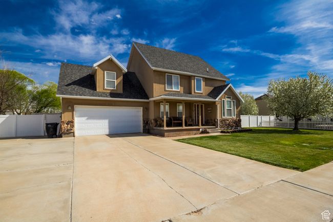 Traditional-style home featuring a porch, a front lawn, driveway, stone siding, and stucco siding | Image 27