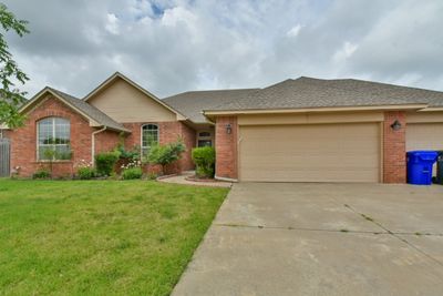 Ranch-style house featuring a garage and a front lawn | Image 1