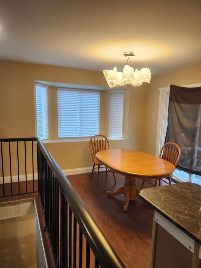 Dining area with a chandelier and wood finished floors | Image 10