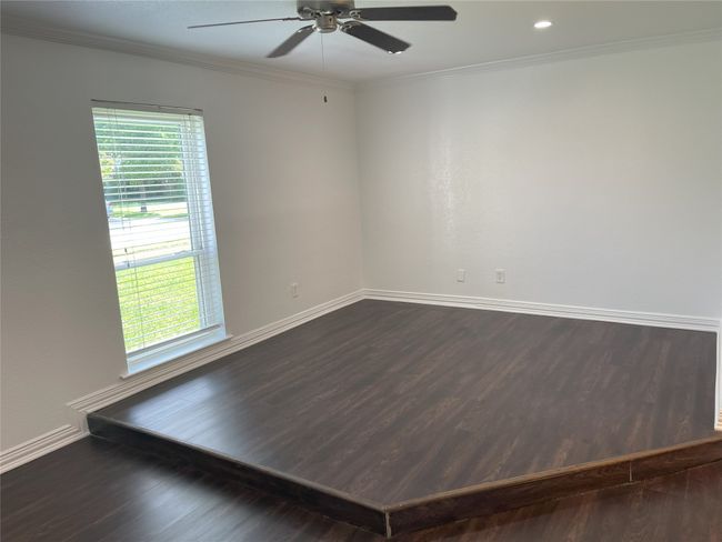Unfurnished room featuring ceiling fan, dark wood finished floors, plenty of natural light, and crown molding | Image 4