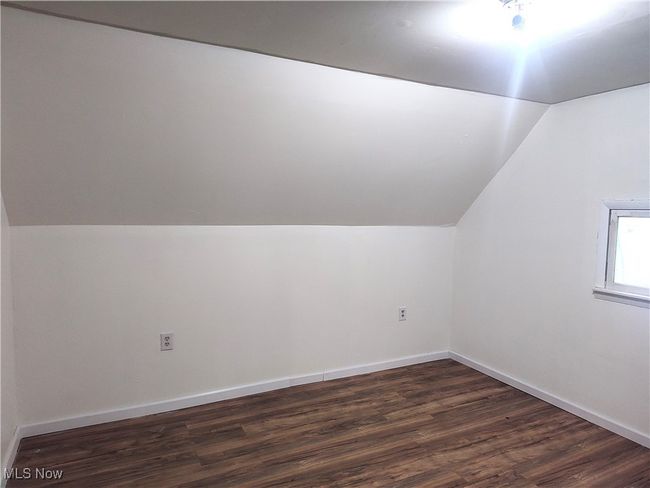 Additional living space with vaulted ceiling, dark wood finished floors, and baseboards | Image 43