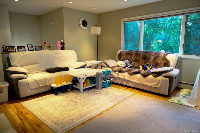 Living room with wood finished floors, recessed lighting, and baseboard heating | Image 9