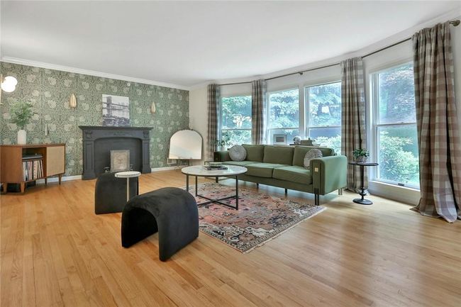 Light pours in through a wall of floor to ceiling windows, reflecting beautifully off the hardwood floors. | Image 5