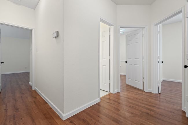 Primary bedroom and secondary bedrooms are separated by a hallway | Image 18